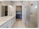 Elegant bathroom with double vanity, modern fixtures, and a glass-enclosed shower, leading to a walk-in closet at 7022 Homeplace St, Castle Rock, CO 80108