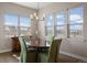 Bright dining room featuring a round table, chandelier, and large windows offering abundant natural light at 7022 Homeplace St, Castle Rock, CO 80108