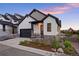 Charming two-story home with a black two car garage and beautifully landscaped front yard at sunset at 7022 Homeplace St, Castle Rock, CO 80108