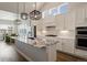 Open kitchen with granite countertops, stainless steel appliances, pendant lighting, and white cabinetry at 7022 Homeplace St, Castle Rock, CO 80108
