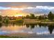 Scenic pond with calm waters reflecting the beautiful sunset and surrounding neighborhood at 7022 Homeplace St, Castle Rock, CO 80108