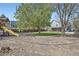 Large backyard with a wooden playset and lush greenery, perfect for outdoor activities at 13330 York Way, Thornton, CO 80241