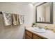 Charming half bath features a classic vanity with decorative mirror and patterned towels at 13330 York Way, Thornton, CO 80241