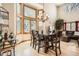 Elegant dining area adjacent to living room, featuring hardwood floors, a wooden table, and large windows at 13330 York Way, Thornton, CO 80241