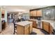 Spacious kitchen with stainless steel appliances, wood cabinets, a center island, and hardwood floors, open to living area at 13330 York Way, Thornton, CO 80241