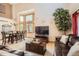 Spacious living room with high ceilings, large windows, hardwood floors, a leather sofa, and a decorative tree at 13330 York Way, Thornton, CO 80241