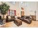 Inviting living room with tall ceilings, hardwood floors, comfortable leather furniture, a decorative tree, and lots of light at 13330 York Way, Thornton, CO 80241