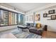 Bright living room features large windows with city views, modern decor, and stylish furnishings at 1750 Wewatta St # 627, Denver, CO 80202