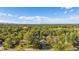 Expansive aerial view of home surrounded by lush trees and a sprawling landscape under a blue sky at 9345 W Iowa Pl, Lakewood, CO 80232