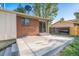 Outdoor patio and brick exterior, with fenced yard and a sliding door access to the home at 9345 W Iowa Pl, Lakewood, CO 80232