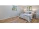 Bedroom with hardwood floors, neutral walls, two windows, and beautifully decorated bed at 9345 W Iowa Pl, Lakewood, CO 80232