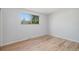Bedroom features hardwood floors, neutral walls, and a window with beautiful green trees at 9345 W Iowa Pl, Lakewood, CO 80232