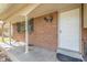 Inviting front porch with brick facade, covered entrance, and stylish exterior lighting at 9345 W Iowa Pl, Lakewood, CO 80232