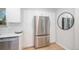 Bright kitchen features white cabinets and stainless steel refrigerator and appliances at 9345 W Iowa Pl, Lakewood, CO 80232
