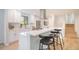 Bright kitchen boasts white cabinets, quartz countertops, stainless appliances, and bar seating at 9345 W Iowa Pl, Lakewood, CO 80232