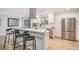 Modern kitchen with stainless steel appliances, white cabinetry, and a breakfast bar at 9345 W Iowa Pl, Lakewood, CO 80232