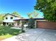 Beautifully landscaped front yard leads to this charming home with a wooden garage door and brick accents at 11569 W 27Th Ave, Lakewood, CO 80215
