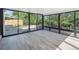Bright sunroom featuring large windows, wood floors, and serene backyard views at 11569 W 27Th Ave, Lakewood, CO 80215