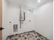 Functional utility area featuring modern water heater and unique geometric tile flooring at 11569 W 27Th Ave, Lakewood, CO 80215