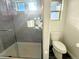 Modern bathroom featuring a glass shower door, a toilet, and stylish gray accents at 17908 E 54Th Ave, Denver, CO 80249