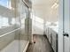 Modern bathroom featuring dual sinks, a glass shower door, and stylish gray cabinets at 17908 E 54Th Ave, Denver, CO 80249