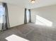 Bright, airy bedroom featuring neutral tones, carpet, and natural light from the large window with curtains at 17908 E 54Th Ave, Denver, CO 80249