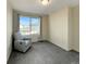 Cozy bedroom with a comfortable chair, neutral carpet, and a window providing natural light and outdoor views at 17908 E 54Th Ave, Denver, CO 80249