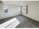 Bright bedroom featuring neutral carpet, two windows with light curtains, and plenty of natural light at 17908 E 54Th Ave, Denver, CO 80249