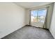 Bedroom with neutral carpet and a large window with curtains providing natural light and community views at 17908 E 54Th Ave, Denver, CO 80249