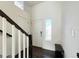 Inviting entryway featuring dark hardwood floors, a bench, and natural light from a frosted glass window at 17908 E 54Th Ave, Denver, CO 80249