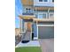 Close up of a modern two-story home's entrance with a brown front door and a gray front-facing garage at 17908 E 54Th Ave, Denver, CO 80249