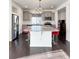 A full shot of the kitchen featuring gray cabinets, granite countertops, stainless appliances, and dark hardwood floors at 17908 E 54Th Ave, Denver, CO 80249