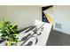 Bright living room with neutral carpet featuring a decorated accent wall, potted plants, and a vent at 17908 E 54Th Ave, Denver, CO 80249