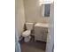 Nicely remodeled bathroom featuring gray tiled floor, a sink with mirror, and toilet at 5677 S Lowell Blvd, Littleton, CO 80123