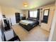 This is a cozy bedroom with neutral walls, lots of light and a black bed at 5677 S Lowell Blvd, Littleton, CO 80123