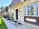 Charming townhome with brick facade, landscaped front yard, and walkway leading to the front door at 5677 S Lowell Blvd, Littleton, CO 80123