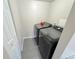 Efficient laundry area with modern machines, tiled floor, and neutral walls at 5677 S Lowell Blvd, Littleton, CO 80123