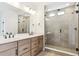 Bright bathroom featuring an updated vanity, dual sinks, and a glass-enclosed shower at 8376 Cokedale Dr, Littleton, CO 80125