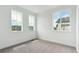 A cozy bedroom bathed in natural light with three large windows overlooking the community at 8376 Cokedale Dr, Littleton, CO 80125