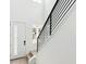 Bright stairwell with white walls, wood stairs, and black metal railing at 8376 Cokedale Dr, Littleton, CO 80125