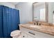 Full bathroom boasts a marble countertop vanity and shower with blue shower curtain at 1566 S Syracuse St, Denver, CO 80231