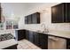 A full view of the kitchen showcasing the tiled countertops and black cabinets at 1566 S Syracuse St, Denver, CO 80231