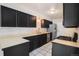 The kitchen features dark cabinetry, a stainless steel dishwasher and tile flooring at 1566 S Syracuse St, Denver, CO 80231