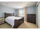 Bright bedroom with a dark wood bed frame and neutral colored walls at 5451 W 73Rd Ave, Westminster, CO 80003