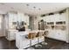 Modern kitchen featuring white cabinetry, a center island with seating, stainless steel appliances, and stylish backsplash at 5451 W 73Rd Ave, Westminster, CO 80003