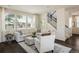 Bright living room with large windows, dark hardwood floors, and a comfortable seating arrangement with many windows at 5451 W 73Rd Ave, Westminster, CO 80003