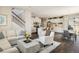 Open-concept living space with stylish furnishings, a modern kitchen, dining area, and beautiful hardwood floors at 5451 W 73Rd Ave, Westminster, CO 80003