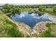 Scenic pond with a wooden pier and gazebo surrounded by lush greenery and sky reflection at 5451 W 73Rd Ave, Westminster, CO 80003
