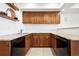 Basement kitchenette with wooden cabinets, granite countertops, and open shelves with stylish decor at 5582 Twilight Way, Parker, CO 80134