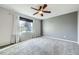 The bedroom has plush carpet, ceiling fan, large window with white and gray curtains and blinds at 19357 E 40Th Ave, Denver, CO 80249